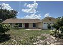 Charming single-story home featuring a red front door, two-car garage and lush greenery in a tranquil setting at 6610 Pampus Dr, Orlando, FL 32819