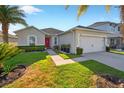Inviting single-story home with vibrant green lawn and a red front door at 826 Sheen Cir Cir, Haines City, FL 33844