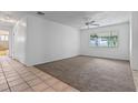 Bright, carpeted living room with an adjacent tiled bathroom and view of an enclosed porch at 885 Little Bend Rd, Altamonte Springs, FL 32714