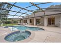 A luxurious screened-in pool with a jacuzzi and ample space for lounging and entertaining at 11648 Grand Bay Blvd, Clermont, FL 34711