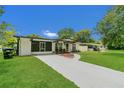 Charming home with well-maintained lawn, mature trees, and a curved walkway to the front door at 1208 Baltimore Dr, Orlando, FL 32810