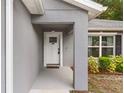 Covered entry to the house showing the front door, landscaping, and exterior paint at 122 Seville Rd, Auburndale, FL 33823