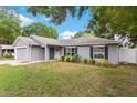 Beautiful single-story home boasts manicured landscaping, a white front door, and neutral gray paint at 122 Seville Rd, Auburndale, FL 33823