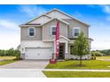Two-story home featuring a two-car garage, stone accents, and a well-manicured front lawn at 1262 Champions Dr, Daytona Beach, FL 32124