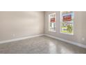 Bright, airy living room with tile flooring and large windows overlooking the front yard at 1262 Champions Dr, Daytona Beach, FL 32124