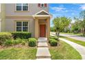 Townhome entrance featuring a covered porch, a landscaped front yard, and a neatly maintained walkway at 12963 Garridan Ave, Windermere, FL 34786