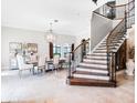 Elegant dining room featuring a staircase with iron railings, a modern chandelier, and tile flooring at 1417 Terralago Pl, Oviedo, FL 32765