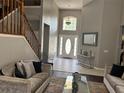 Bright foyer with high ceilings, a decorative mirror, and a staircase with wooden banisters at 1445 Valley Pine Cir, Apopka, FL 32712