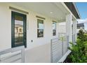 Inviting front porch featuring a modern railing, stylish door, and ample natural light at 16454 Silver Brook Way, Winter Garden, FL 34787