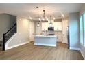 Open concept living space featuring hardwood floors and a modern kitchen with stainless steel appliances at 16454 Silver Brook Way, Winter Garden, FL 34787