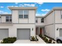 Charming two-story townhouse featuring a one-car garage, neutral paint scheme, and landscaped walkway to the front door at 1900 Erudite Way, Winter Park, FL 32792