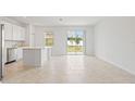 Open living space with tile floors, white cabinets, stainless steel appliances, and sliding glass doors at 2716 Pierr St, Davenport, FL 33837