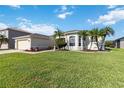 Landscaped front yard of home with lush green grass and beautiful tropical palm trees at 2746 Windsorgate Ln, Orlando, FL 32828