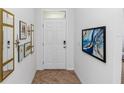 Bright entryway with decorative wall art and a white door with a transom window at 296 Inman Blvd, Winter Haven, FL 33881