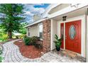 Inviting entrance with brick detail, stone walkway, and a red door, creating a warm welcome at 3065 Bridgehampton Ln, Orlando, FL 32812