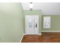 Bright foyer with hardwood floors, featuring an oval-windowed white door and plantation shutters at 3065 Bridgehampton Ln, Orlando, FL 32812