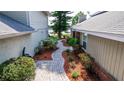 Landscaped side yard showcases a brick pathway and lush greenery leading toward a water view at 3065 Bridgehampton Ln, Orlando, FL 32812