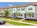 Street view of modern townhomes with landscaped lawns, sidewalks, and visitor parking at 3335 Azolla St, Orlando, FL 32808