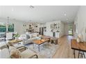 Bright open-concept living area with wood floors, modern furnishings, and a bar area at 3650 Grant Blvd, Orlando, FL 32804