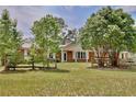 Charming brick home featuring a large front yard with mature trees and a rustic wooden fence at 4802 Anton Ave, Apopka, FL 32712