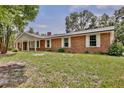 Well-maintained brick home featuring a covered porch, white trim, and lush green landscaping at 4802 Anton Ave, Apopka, FL 32712