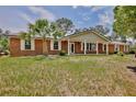 Inviting brick home with a covered porch and classic white columns, set on a lush green lawn at 4802 Anton Ave, Apopka, FL 32712