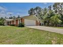 Spacious home with attached garage, complemented by a well-manicured lawn and a paved driveway at 4802 Anton Ave, Apopka, FL 32712