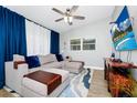 Comfortable living room with an elegant sectional sofa, ceiling fan and entertainment center with a mounted television at 7616 Simms Ave, Orlando, FL 32812