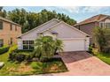 Charming single-story home with a well-maintained lawn, mature palm trees, and an attached two-car garage at 879 Nonastone Run, Casselberry, FL 32707