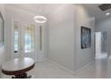 Bright foyer featuring marble floors, elegant lighting, and a decorative glass front door at 9780 Cypress Pine St, Orlando, FL 32827