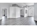Bright, open living room with light gray walls, archways, and wood-look flooring at 9821 8Th Ave, Orlando, FL 32824