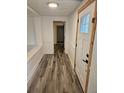 Bright hallway with wood-look floors leads to the front door and other rooms at 985 N Village Dr, Deltona, FL 32725