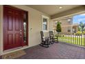 Inviting front porch with rocking chairs and a brick floor for a relaxing outdoor experience at 9873 Lost Creek Dr, Winter Garden, FL 34787