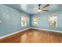 Bright bedroom featuring hardwood floors, three windows, and a contemporary ceiling fan at 1003 S Center St, Eustis, FL 32726