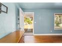 Inviting living room with hardwood floors, light blue walls, and an open door to the front yard at 1003 S Center St, Eustis, FL 32726