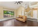 Bright living room boasts hardwood floors, a fireplace, and staircase leading to the second floor at 120 E Greentree Ln, Lake Mary, FL 32746