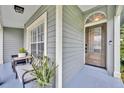 Inviting covered front porch featuring a glass front door, potted plants, and a cozy bench at 1576 Crosswind Cir, Orlando, FL 32825