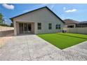 Clean backyard featuring concrete patio, artificial turf, and a sliding glass door at 1727 Butterfly Way, Longwood, FL 32750