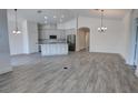Open-concept kitchen featuring an island, modern appliances, and light wood-look flooring at 1727 Butterfly Way, Longwood, FL 32750