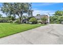 Wide view of the home from a concrete driveway, showing mature landscaping and lawn at 1745 Seneca Blvd, Winter Springs, FL 32708