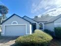 Well-maintained single-story home featuring an attached garage, manicured lawn, and front shrubs at 215 Hollowbrook Cir, Daytona Beach, FL 32114