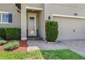 The front door of the home with well-manicured shrubbery, pavers and fresh mulch at 2325 Bella Luna Cir, Lakeland, FL 33810