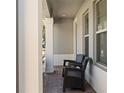 Cozy front porch features brick flooring, two chairs, and ample natural light, perfect for relaxing at 2530 Domenico Paul Way Way, Orlando, FL 32810