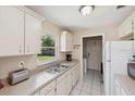 Bright kitchen with white cabinets and a double sink beneath a window at 2822 Fulford St, Deltona, FL 32738