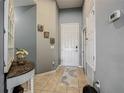 Inviting entryway with tiled floors, decorative console table, and neutral paint, creating a welcoming atmosphere at 2860 Orange Haven Way, Kissimmee, FL 34746