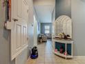 Hallway with tiled flooring leading to the living area, featuring a decorative table and a view of the living room at 2860 Orange Haven Way, Kissimmee, FL 34746