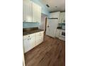 White cabinets and wood-look flooring in this kitchen with a full appliance suite at 30965 E Thyme Ave, Eustis, FL 32736