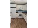 Bright kitchen features white cabinets, appliances, and lots of countertop space at 30965 E Thyme Ave, Eustis, FL 32736