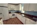 Bright kitchen features white cabinets, appliances, and lots of countertop space at 30965 E Thyme Ave, Eustis, FL 32736