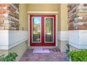 Elegant double front doors with glass inlays and stone accents, inviting entry to the home at 33919 Terragona Dr, Sorrento, FL 32776